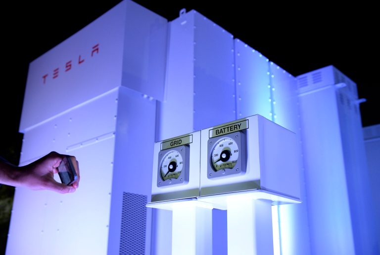 A guests takes photographs of the Powerpack system after Elon Musk, CEO of Tesla unveiled suit of batteries for homes, businesses, and utilities at Tesla Design Studio April 30, 2015 in Hawthorne, Calif.Â Mark MacCracken, the CEO of energy storage firm Calmac, which makes the Ice Bank, says his ice-based system takes a different approach to his big-battery counterparts, such as Tesla Motors CEO Elon Musk.Â Musk's new grid-based batteries are priced at $300-$400 per kilowatt hour, while the Ice Bank is $100 per kilowatt hour, according to MacCracken.Â (Photo by Kevork Djansezian/Getty Images)