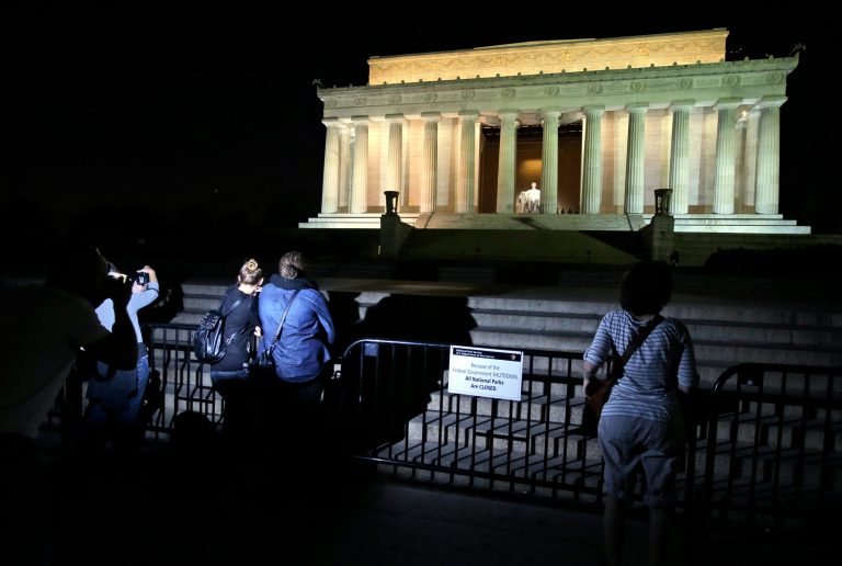   People take pictures in front of the steps of the closed Lincoln Memorial, Tuesday, Oct. 1, 2013, in Washington. The museums that draw millions of visitors to the National Mall closed their doors Tuesday, memorials were barricaded and trash will go uncollected in the nation's most-visited national park due to the first government shutdown in 17 years. (AP Photo/Alex Brandon)  