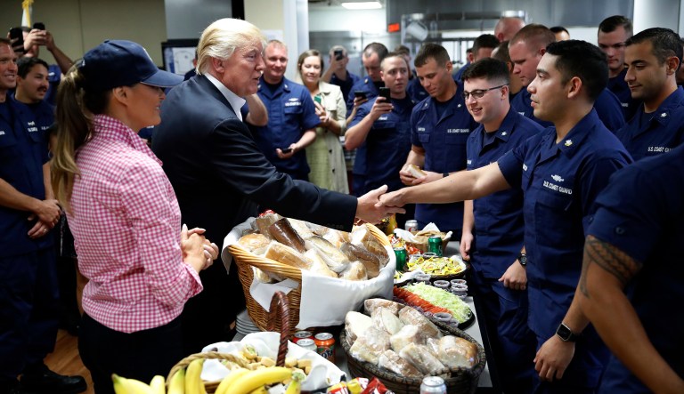 President Donald Trump, with first lady Melania Trump, greets and hands out sandwiches to members of the U.S. Coast Guard, at the Lake Worth Inlet Station, on Thanksgiving, Thursday, Nov. 23, 2017, in Riviera Beach, Fla. (AP Photo/Alex Brandon)