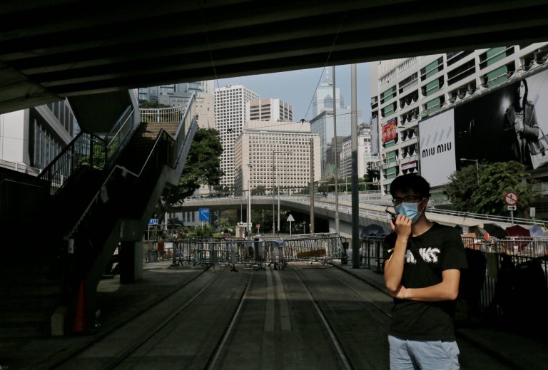 A pro-democracy supporter talks on walkie-talkie on a street in the occupied areas surrounding the government complex in Hong Kong Wednesday, Oct. 8, 2014. Crowds of protesters who filled Hong Kong's streets with demands for more democracy thinned dramatically Tuesday after student leaders and the government agreed to hold talks in the increasingly frustrated city.  (AP Photo/Vincent Yu)