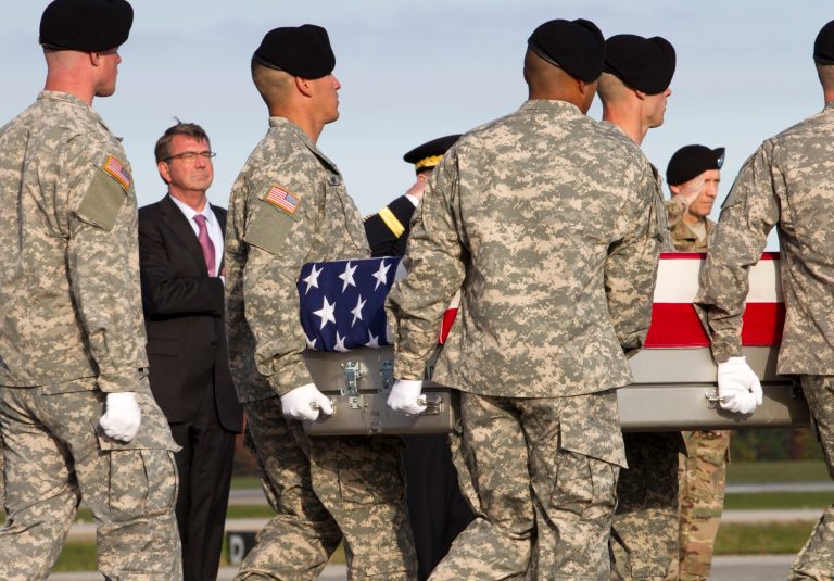 Defense Secretary Ash Carter salutes the transfer case containing the remains of Army Master Sgt. Joshua L. Wheeler of Roland, Okla., upon arrival at Dover Air Force Base, Del., on Saturday, Oct. 24, 2015. (AP Photo/Jose Luis Magana)