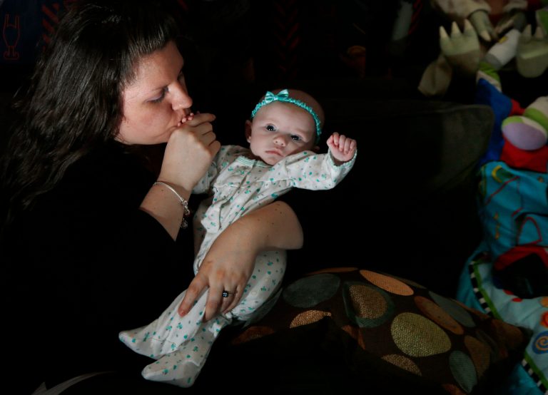 Jennifer Fontaine kisses her baby daughter, Morgan, at her parents' home in Methuen, Mass., Tuesday, Feb. 25, 2014. A simple test that looks for fetal DNA in a pregnant woman's blood is far more accurate at detecting or ruling out Down syndrome and other common chromosome disorders than other screening methods used now, a major study finds. (AP Photo/Elise Amendola)