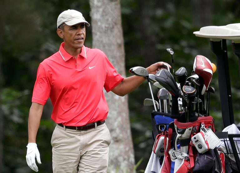 President Barack Obama selects a club while golfing at Farm Neck Golf Club, in Oak Bluffs, Mass., on the island of Martha's Vineyard, Saturday, Aug. 23, 2014. (AP Photo/Steven Senne)