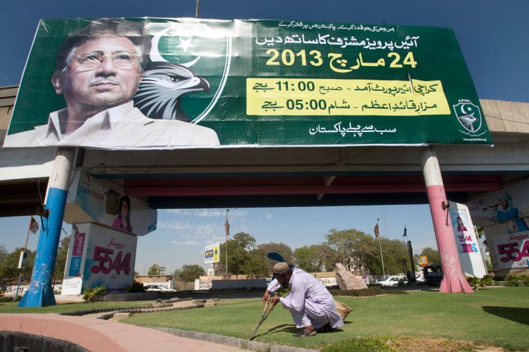 A Pakistani gardener works under a banner of Pakistan's President Pervez Musharraf, reading 