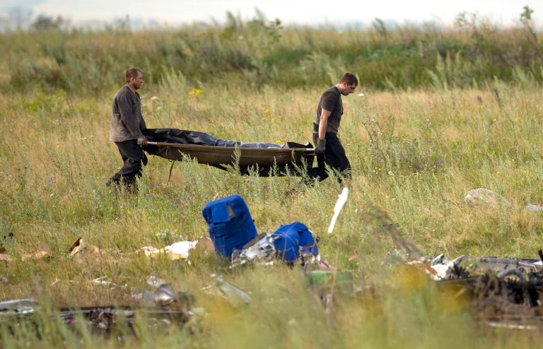 Emergency workers carry the body of a victim at the crash site of Malaysia Airlines Flight 17 near the village of Hrabove, eastern Ukraine, Saturday, July 19, 2014. World leaders demanded Friday that pro-Russia rebels who control the eastern Ukraine crash site of Malaysia Airlines Flight 17 give immediate, unfettered access to independent investigators to determine who shot down the plane. (AP Photo/Vadim Ghirda)