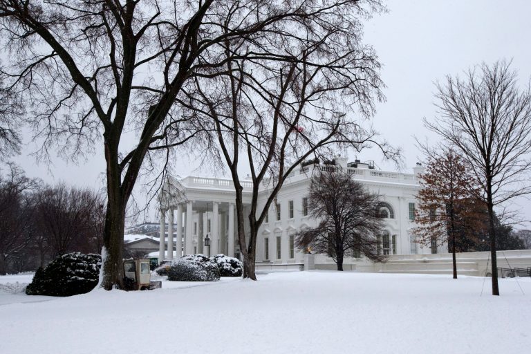 Snow continues to fall as a sidewalk is cleared of snow at the White House in Washington on Feb. 13. After pummeling wide swaths of the South, a winter storm dumped nearly a foot of snow in Washington and threatened more power outages, traffic headaches and widespread closures for millions of residents. (AP Photo/Jacquelyn Martin)