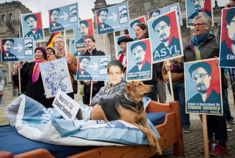 Students of the Muthesius Art Academy stand around a bed for Edward Snowden in front of a Snowden poster in Kiel, Germany, in June. The academy wants to offer Snowden asylum symbolically to mark the one-year anniversary of the NSA whistleblowing. (Photo: Ruben Neugebauer/picture-alliance/dpa/AP Images)
