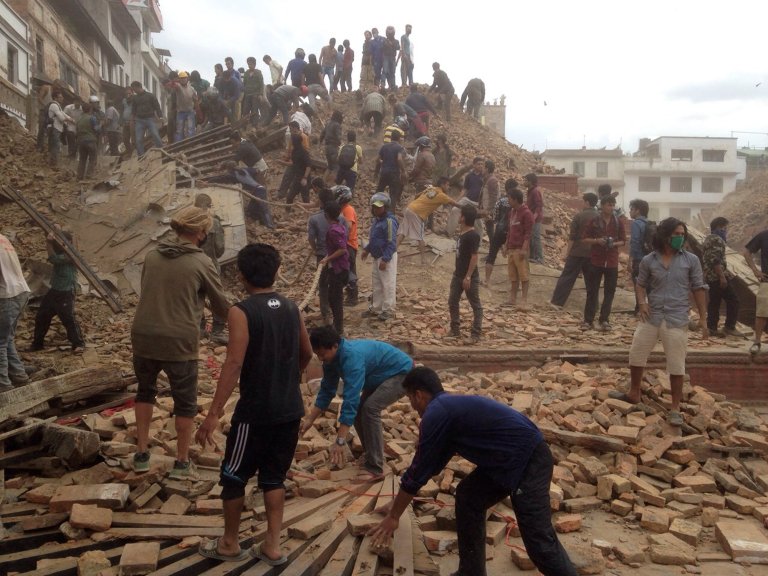 Volunteers help with rescue work at the site of a building that collapsed after an earthquake in Kathmandu, Nepal, Saturday, April 25, 2015. A strong magnitude-7.9 earthquake shook Nepal's capital and the densely populated Kathmandu Valley before noon Saturday, causing extensive damage with toppled walls and collapsed buildings, officials said. (AP Photo/ Niranjan Shrestha)