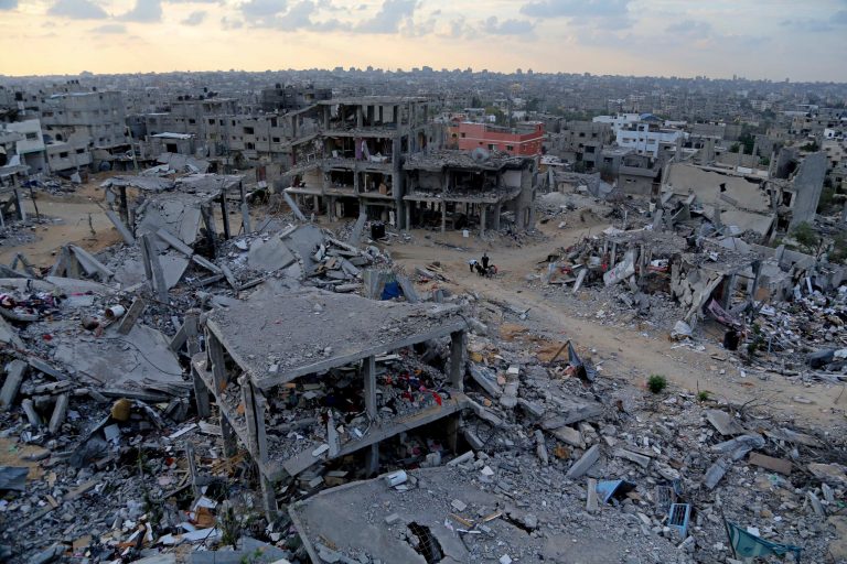 Palestinians sit among the rubble of destroyed buildings in Shijaiyah, a neighborhood of Gaza City in the northern Gaza Strip, Sunday, Oct. 12, 2014. Delegates representing some 50 nations and 20 regional and international organizations attended a donor conference in Cairo, Egypt, on Sunday to help Gaza rebuild after the war between Israel and Gaza's militant Islamic group Hamas this summer. (AP Photo/Adel Hana)