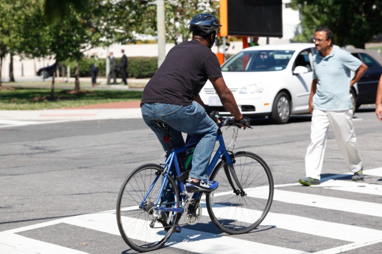 A cyclist prepares to cross a busy intersection on Capitol Hill. (Graeme Jennings/Examiner photo)