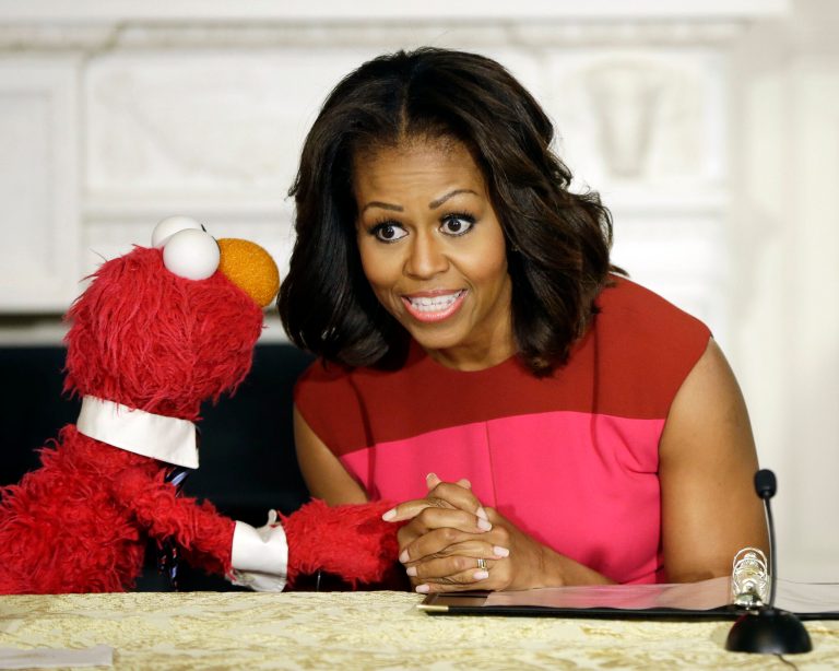 First lady Michelle Obama, center, with PBS Sesame Street's characters Elmo, left, attend an event to help promote fresh fruit and vegetable consumption to kids in an event in the State Dining Room of the White House in Washington, Wednesday, Oct. 30, 2013. Sesame Workshop and the Produce Marketing Association (PMA) joined in Partnership for a Healthier America (PHA) in announcing a 2-year agreement to making healthy choices by using the Sesame Street characters to help deliver the messages about fresh fruits and vegetables. (AP Photo/Pablo Martinez Monsivais)