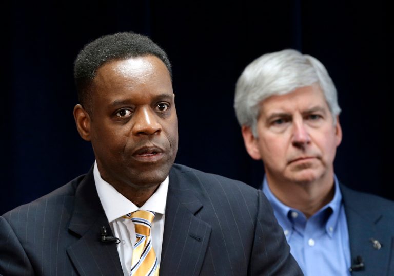 FILE - In this March 14, 2013, file photo, Detroit emergency manager Kevyn Orr, left, speaks at a news conference in Detroit as Michigan Gov. Rick Snyder, who appointed Orr, listens. Orr's success in shepherding Detroit through its historic bankruptcy will leave him unemployed, at least temporarily, when and if his task in the Motor City is complete. (AP Photo/Paul Sancya, File)
