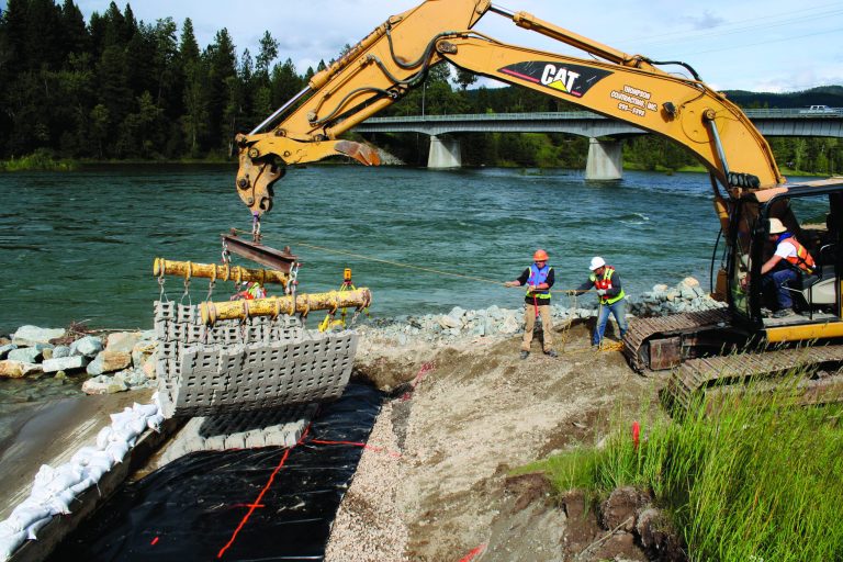 In this 2001 photo provided by the Environmental Protection Agency, EPA contractors work on a boat ramp installed by the agency at Riverfront Park in Libby, Mont. Following a 12-year cleanup, officials say a wedding in the newly-constructed Riverfront Park is lined up for the summer and a blues festival is scheduled for early August. It's a dose of normalcy that marks a major milestone for Libby, a mining town of about 3,000 people near the Canadian border that has become synonymous with lung disease and death after an estimated 400 people to date have been killed by asbestos exposure. (AP Photo/EPA)