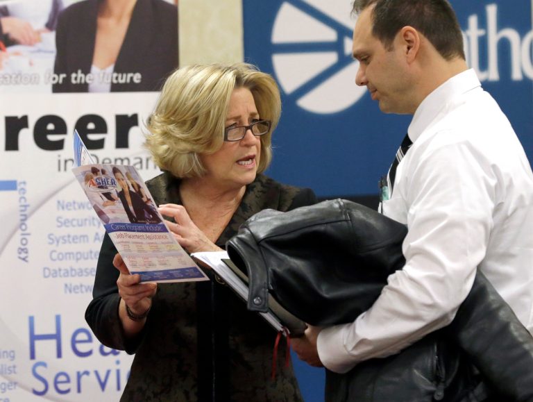 FILE - In this Wednesday, Jan. 22, 2014 file photo, recruiter Valera Kulow, left, speaks with job seeker Leonardo Vitiello during a career fair in Dallas. The Labor Department reports the number of people who applied for unemployment benefits last week on Thursday, June 5, 2014. (AP Photo/LM Otero, File)