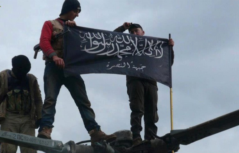 FILE - This Friday, Jan. 11, 2013 file citizen journalism image provided by Edlib News Network, ENN, which has been authenticated based on its contents and other AP reporting, shows rebels from al-Qaida affiliated Jabhat al-Nusra waving their brigade flag as they step on the top of a Syrian air force helicopter, at Taftanaz air base that was captured by the rebels, in Idlib province, northern Syria.  It is announced Wednesday April 23, 2014, that French authorities are taking steps to crack down on the flow of young would-be jihadis embarking to fight in Syria's civil war, with measures including travel restrictions and withdrawal of passports, and increased monitoring of alleged jihadi web sites. (AP Photo/Edlib News Network ENN, FILE)