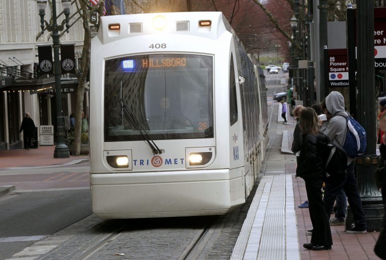 Riders wait to board an incoming MAX train in Portland, Ore., Monday. (AP/Don Ryan)
