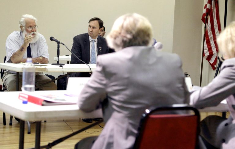 Darryl Malek-Wiley, left, with the Sierra Club in New Orleans speaks as U.S. Congressman Pete Olson (R-Texas), right, listens at an Environmental Protection Agency public hearing, Tuesday, Aug. 5, 2014, in Galena Park, Texas. The EPA is considering a rule that would force refineries to monitor emissions of benzene. (AP Photo/Pat Sullivan)
