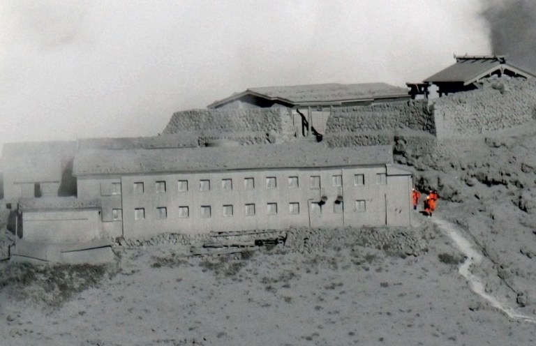 Rescuers conduct a search operation near the peak of ash-covered Mount Ontake in central Japan, Thursday, Oct. 2, 2014. Saturday's eruption on Mount Ontake was the worst fatal eruption in postwar history in Japan. (AP Photo/Kyodo News) JAPAN OUT, MANDATORY CREDIT