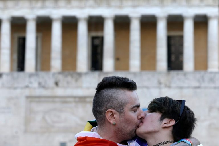 A gay couple kisses during a protest outside Greece's Parliament in Athens on Friday, Sept. 5, 2014. Several hundred people took part in the peaceful march to Parliament, which is debating draft legislation to outlaw Holocaust denial and expand prosecution powers against the incitement of racial violence. Gay and Lesbian rights groups complain that the proposed legislation will not adequately address attacks on homosexual people, which they say are on the rise. (AP Photo/Thanassis Stavrakis)
