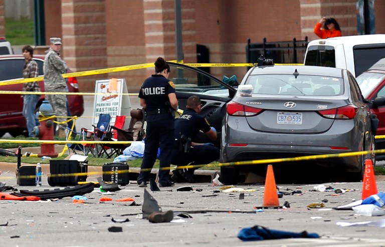 Police investigate a damaged car after the vehicle crashed into a crowd of spectators during the Oklahoma State University homecoming parade, causing multiple injuries, on Saturday. (Sarah Phipps/The Oklahoman via AP)