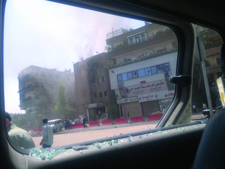 This citizen journalist image shot through a broken car window shows smoke billowing from a building after fighting between rebels and Syrian troops in the Yarmouk camp for Palestinian refugees in south Damascus, Syria, Saturday, July 21, 2012. This week, fierce fighting between troops and rebels reached the Syrian capital, the central bastion of Bashar Assad's rule, shattering parts of the city and sending thousands of people fleeing to neighboring Lebanon and Iraq. Activists and residents reported a tense calm in Damascus Saturday but said sporadic gunfire and explosions could be heard throughout the night. (AP Photo)