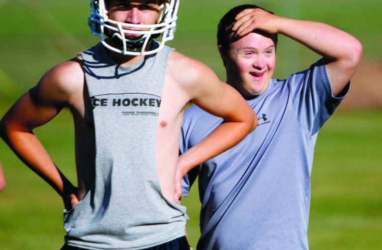 ** HOLD FOR RELEASE AT 12:01 A.M. EST ON FRIDAY, JAN. 25, 2013 ** FILE - In this Aug. 6, 2012 file photo, 19-year-old Eric Dompierre, right, who has Down syndrome and is the kicker for the Ishpeming High School varsity football team, arrives on the field for the first day of practice at the Ishpeming Playgrounds in Ishpeming, Mich. Breaking new ground, the U.S. Education Department is telling schools Friday, Jan. 25, 2013, they must include students with disabilities in sports programs or provide equal alternative options. The directive, reminiscent of the Title IX expansion of athletic opportunities for women, could bring sweeping changes to school budgets and locker rooms for years to come. (AP Photo/Detroit Free Press, Andre J. Jackson, File)