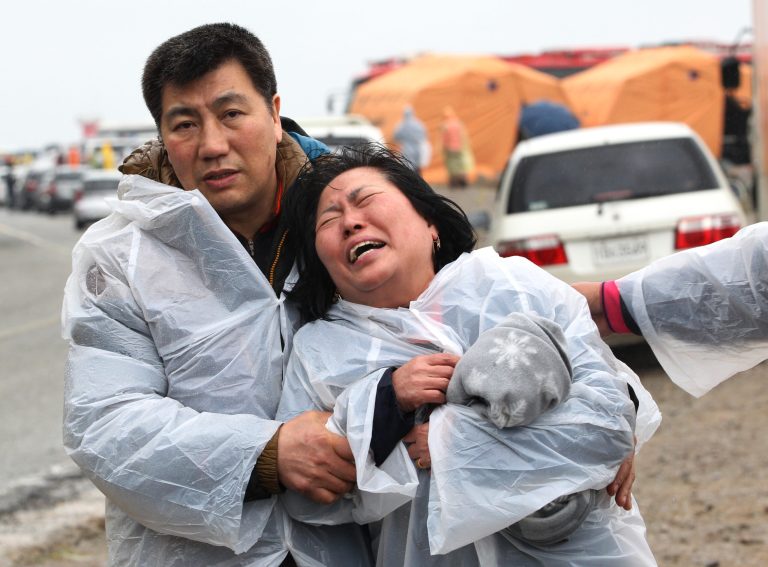 A relative of a passenger aboard a sunken ferry weeps at a port in Jindo, South Korea, South Korea, Thursday, April 17, 2014. Strong currents, rain and bad visibility hampered an increasingly anxious search Thursday for more than 280 passengers still missing a day after their ferry flipped onto its side and sank in cold waters off the southern coast of South Korea. (AP Photo/Ahn Young-joon)