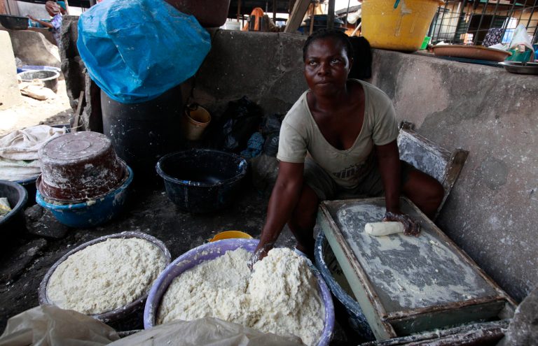 In this photo taken Friday May 3, 2013 a woman produces cassava flour from cassava in a market in Lagos, Nigeria. Scientists say a disease destroying entire crops of cassava has spread out of East Africa into the heart of the continent, is attacking plants as far south as Angola and now threatens to move west into Nigeria, the world's biggest producer of the potato-like root that helps feed 500 million Africans. (AP Photo/Sunday Alamba)