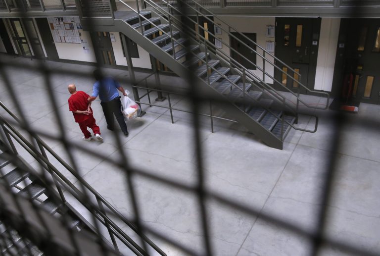 A guard escorts an immigrant detainee from his 'segregation cell' back into the general population at the Adelanto Detention Facility on November 15, 2013 in Adelanto, California. (Photo by John Moore/Getty Images)