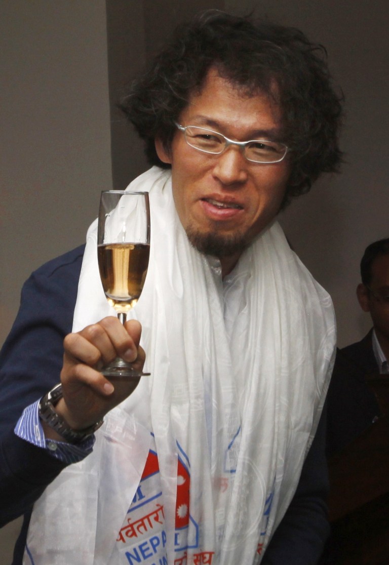   In this Sunday, June 10, 2012 photo, Japanese climber Hirotaka Takeuchi celebrates after he was congratulated by the President of Nepal Mountaineering Association Zimba Zangbu Sherpa in Katmandu, Nepal. Takeuchi, who was nearly killed by an avalanche in 2007, scaled the 8,167-meter-high (26,788-foot-high) Mount Dhaulagiri on May 26 to finish his 17-year mission, has become his country's first person to scale the world's 14 tallest mountains, completing his latest climb in Nepal, mountaineering officials said Monday. (AP Photo/Binod Joshi)  