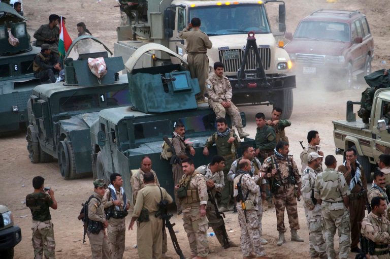 Kurdish troops known as peshmerga prepare to attack Islamic State group positions during a military operation to regain control of some villages. (AP Photo)