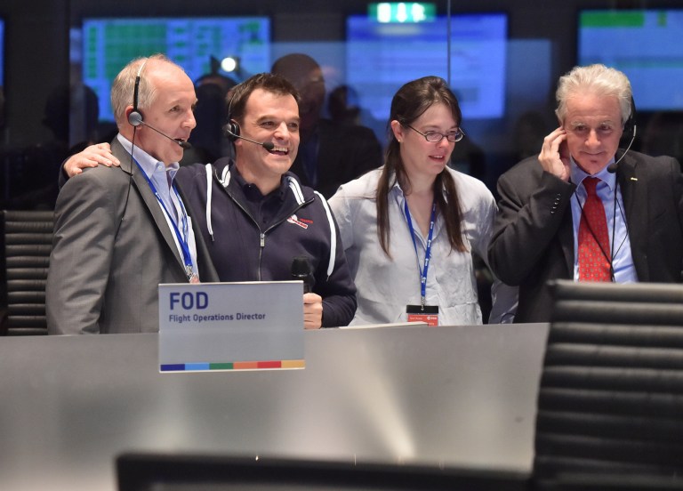 Celebrating scientists in the main control room appear on a video screen at the European Space Agency after the first unmanned spacecraft Philae landed on a comet called 67P/Churyumov-Gerasimenko, in Darmstadt, Germany. (AP Photo/Michael Probst)