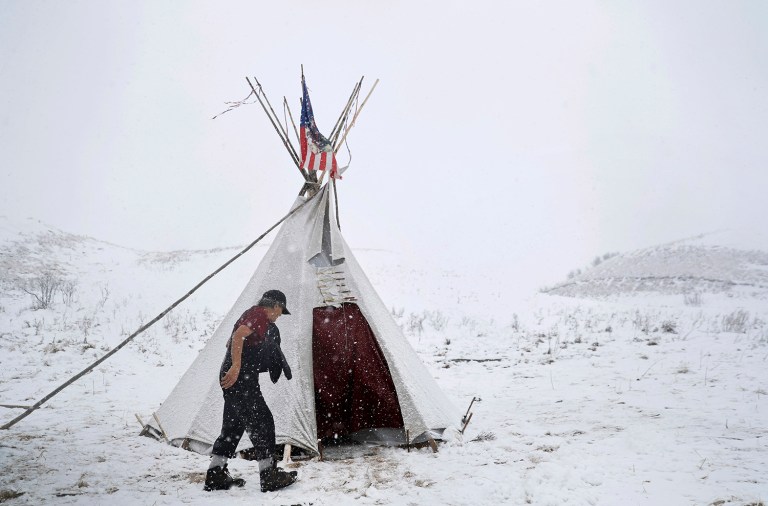 Allen Coomsta Matt walks into his teepee at the Oceti Sakowin camp where people have gathered to protest the Dakota Access oil pipeline as snow begins to fall in Cannon Ball, N.D., Monday, Dec. 5, 2016. (AP Photo/David Goldman)