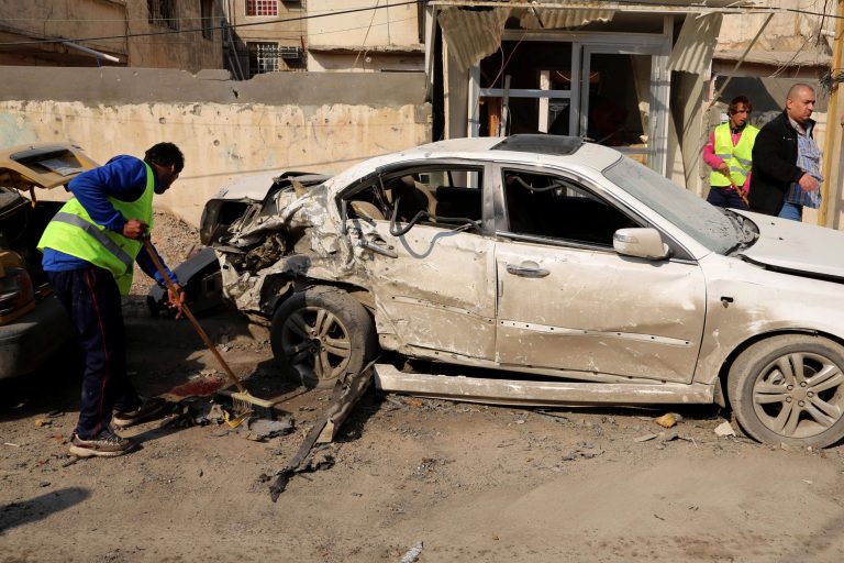 Baghdad municipality workers clean up as civilians inspect the site of a car bomb attack near the Technology University in Sinaa Street in downtown Baghdad, Iraq, on Wednesday. (AP/Karim Kadim)