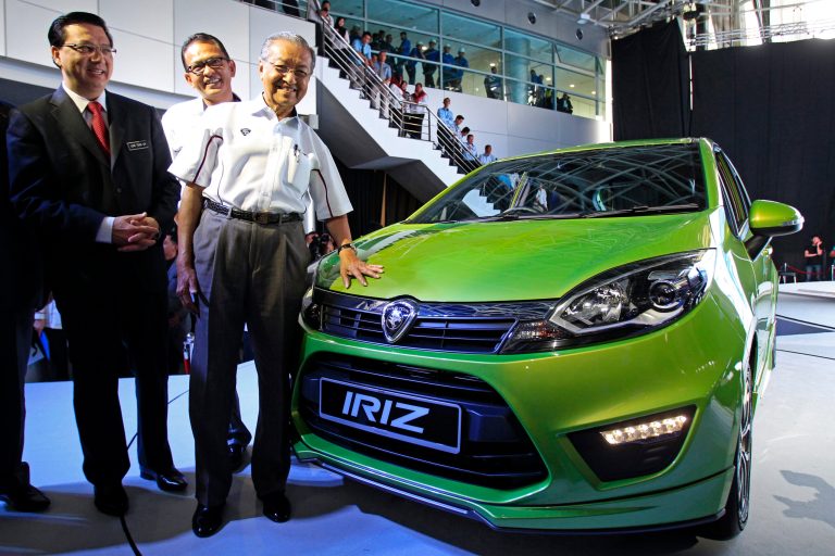 From right, Proton's Chairman Mahathir Mohamad, Proton's Chief Executive Abdul Harith Abdullah and Malaysian Transport Minister Liow Tiong Lai, pose for photos next to the Malaysian automaker's new model 