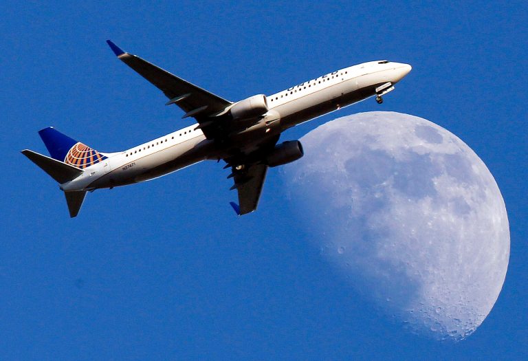 FILE - In this July 17, 2013 file photo, a United Airlines jet approaching Los Angeles International Airport passes in front of a Waxing Gibbous moon. Airfare is up 10.7 percent in the past five years _ after adjusting for inflation _ according to an Associated Press analysis of data from the Airlines Reporting Corp., which processes ticket transactions for airlines and more than 9,400 travel agencies, including websites such as Expedia and Orbitz. ( AP Photo/Nick Ut, File)