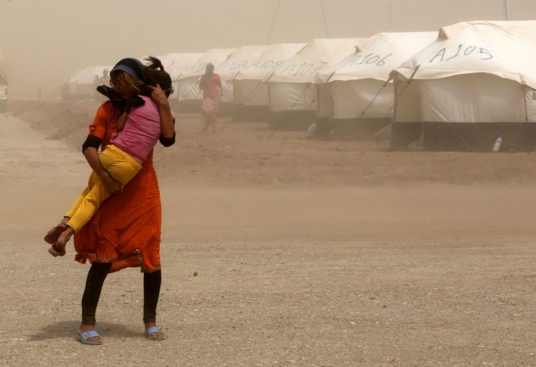 An internally displaced Iraqi woman holds her sister during a sandstorm at a new camp outside the Bajid Kandala camp in Feeshkhabour town, Iraq, Tuesday, Aug. 19, 2014. Some 1.5 million people have been displaced by fighting in Iraq since the Islamic State's rapid advance began in June, and thousands more have died. The scale of the humanitarian crisis prompted the U.N. to declare its highest level of emergency last week. (AP Photo/ Khalid Mohammed)