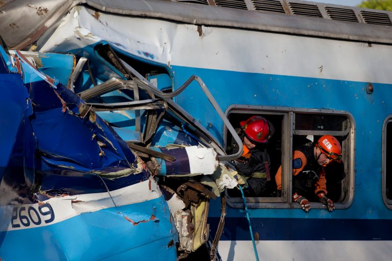 Firefighters work to rescue trapped passengers from a commuter train on the outskirts of Buenos Aires, Argentina, Thursday, June 13, 2013. A two-level train slammed into another that had stopped between stations during the morning commute Thursday. Firefighters and police are pulling passengers from the wreckage. Train operator spokesman Pablo Gunning says there are 
