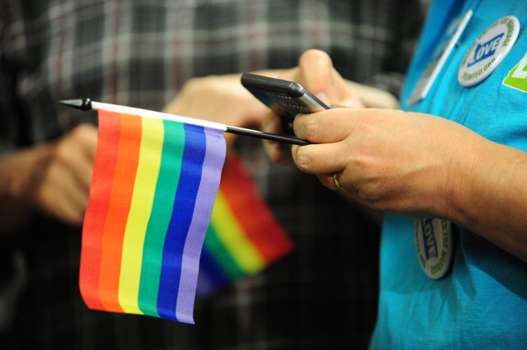 A woman holding a rainbow flags waits in anticipation at the headquarters of Oregon United for Marriage in Portland on May 19th 2014 ahead of Judge Michael McShane's ruling on gay marriage. (Photo by: Alex Milan Tracy/Sipa USA)