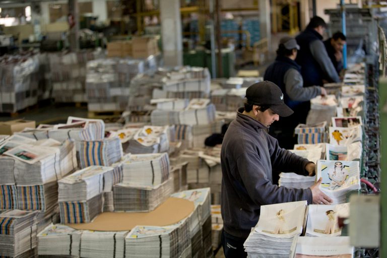 A worker binds magazine pages inside the R.R. Donnelley & Sons printing plant, on the outskirts of Buenos Aires, Argentina, Thursday, Aug. 14, 2014. The global printing company based in the U.S. shuttered its plant Monday amid tough economic times in the South American country. About 200 workers decided to keep working, despite not being paid, until union leaders, in talks with the Labor Ministry, find a solution to reverse the plant layoffs.  (AP Photo/Natacha Pisarenko)