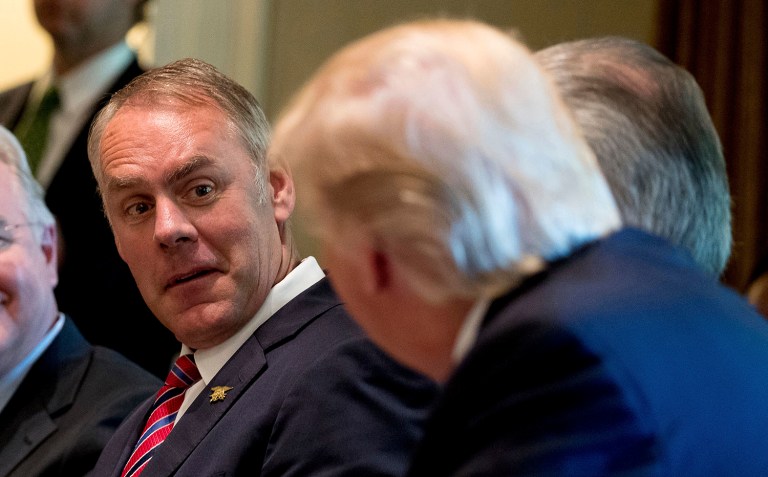FILE- In this June 12, 2017, file photo, Interior Secretary Ryan Zinke, left, listens as President Donald Trump speaks during a Cabinet meeting in the Cabinet Room of the White House in Washington. Zinke said Monday, Sept. 25, that nearly one-third of employees at his department are not loyal to him and Trump, adding that he is working to change the department's regulatory culture to be more business friendly. (AP Photo/Andrew Harnik, File)
