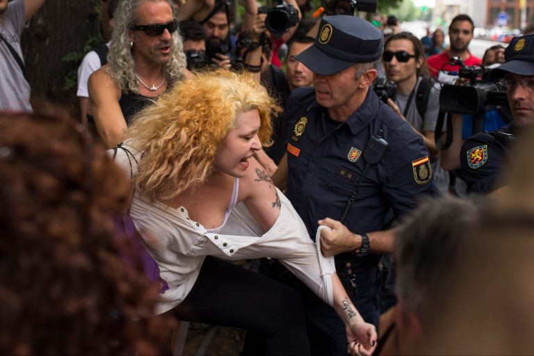 A riot police officer grabs a protestor who was shouting slogans against the monarchy, during a protest against the Monarchy near the parliament in Madrid, Spain, Wednesday, June 11, 2014. Dozens of riot police stopped and frisked protestors as they arrived near the Spanish parliament. Spain's Parliament has voted overwhelmingly in favor of urgent government legislation allowing King Juan Carlos to abdicate this month and hand over his duties to Crown Prince Felipe. The legislation was approved by 299 lawmakers, while 19 voted against and 23 abstained. Several leftist deputies protested, holding up signs demanding a referendum on whether to scrap the monarchy. The Senate is expected to approve the legislation June 17, with 46-year-old Felipe being proclaimed king two days later. (AP Photo/Andres Kudacki)