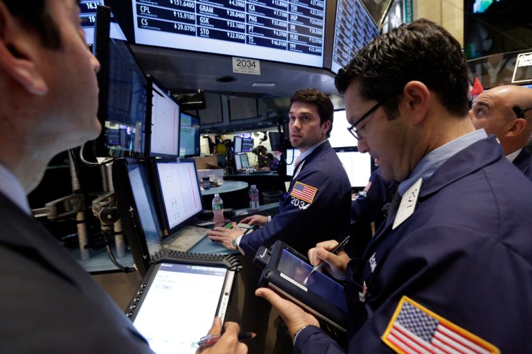 FILE - In this Monday, Nov. 11, 2013, file photo, specialist Joseph Dreyer, center, works with traders on the floor of the New York Stock Exchange. U.S. stock futures are pulling back after the Dow Jones index struck another record high this week. (AP Photo/Richard Drew, File)