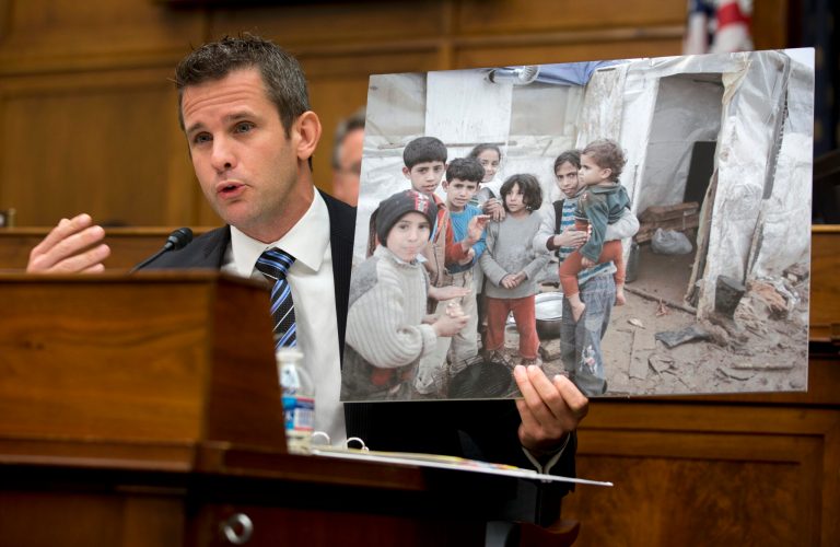 Rep. Adam Kinzinger, R-Ill. holds up a photograph of Syrian children as he speaks on Capitol Hill on Wednesday during a hearing on Syria. (AP Photo/Carolyn Kaster)