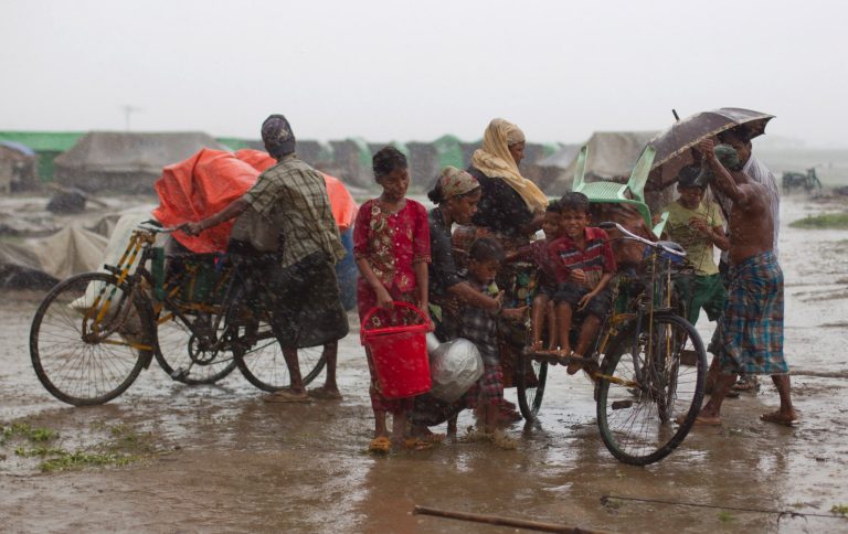 Internally displaced Rohingya people load rickshaws with children and belongings to leave their camp in Sittwe, northwestern Rakhine State, Myanmar, Thursday, May 16, 2013. Tens of thousands of displaced Rohingya people live in the plastic-roofed tents and huts made of reeds, and they distrust nearly any order from a government that barely acknowledges they exist. Even as rain and wind from the edges of Cyclone Mahasen began to pelt the coast near the city on Thursday morning, most people camped there appeared to be staying put. Some, however, were taking down their tents and hauling their belongings away in cycle-rickshaws, or carrying them in bags balanced on their heads. (AP Photo/Gemunu Amarasinghe)