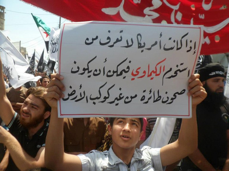 FILE - This Friday, May 3, 2013, citizen journalism image provided by Edlib News Network, ENN, which has been authenticated based on its contents and other AP reporting, show an anti-Syrian regime protester holding up an Arabic placard reading, 