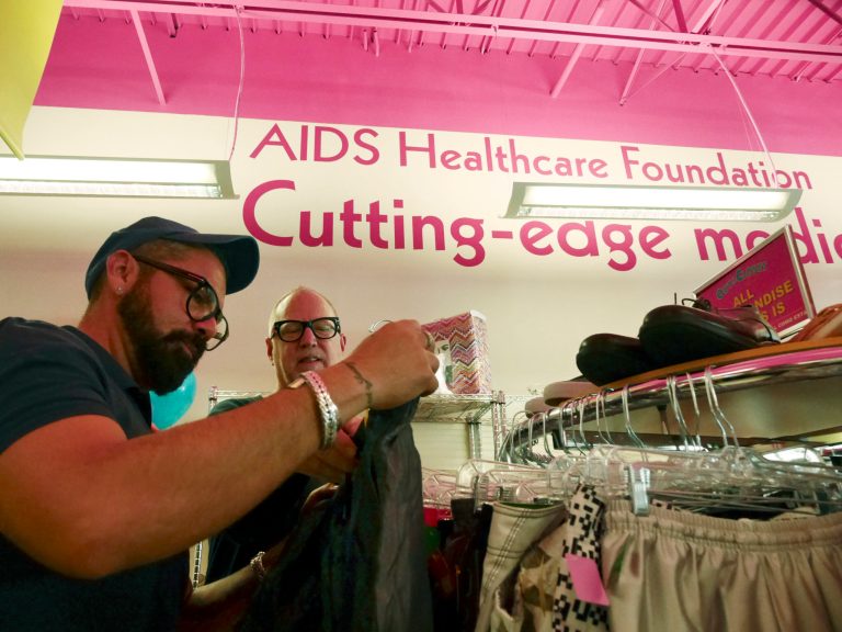 In a Saturday April 19, 2014 photo, Alfonso Serrano, left, and Mark Carrigan shop during the grand opening at the Out of the Closet Thrift Store in Dallas. The stores are part of the AIDS Healthcare Foundation and 96 cents of every dollar earned  goes into supporting AHF clinics serving nearly 300,000 people worldwide. (AP Photo/The Dallas Morning News, Ron Baselice)