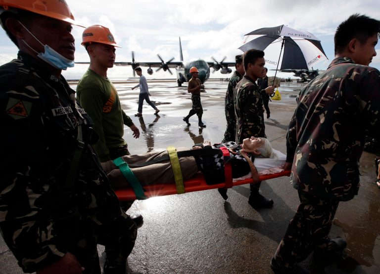 An injured typhoon survivor is carried on a stretcher prior to being airlifted in a military transport plane Wednesday Nov. 13, 2013 from the damaged Tacloban airport at Tacloban city, Leyte province in central Philippines. Typhoon Haiyan, one of the strongest storms on record, slammed into central Philippine provinces Friday, leaving a wide swath of destruction and thousands of people dead. (AP Photo/Bullit Marquez)