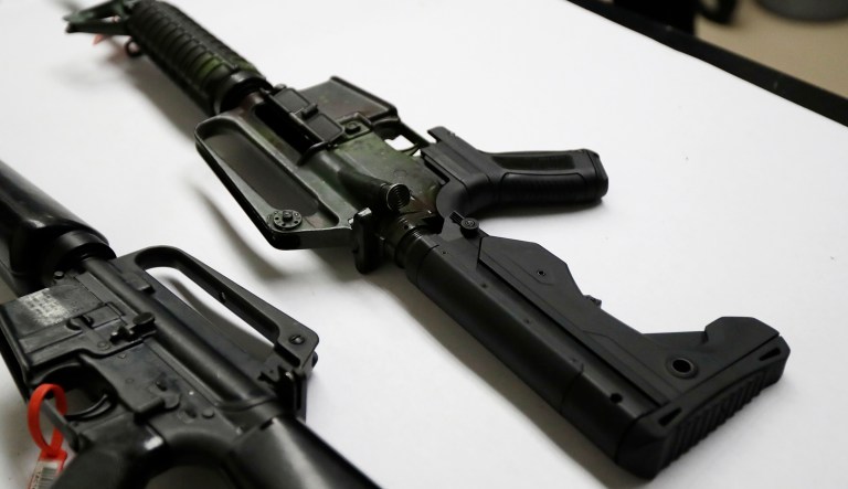 In this Jan. 11 photo, a semi-automatic rifle at right that has been fitted with a so-called 'bump stock' device to make it fire faster sits on a table at the Washington State Patrol crime laboratory in Seattle. President Trump said on Tuesday shortly after White House press secretary Sarah Huckabee Sanders discussed the Florida school shooting that left 17 dead: 