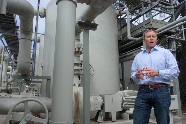 In this April 25, 2014 photo, Joshua Haggmark, interim resources manager for Santa Barbara, Calif., stands next to a desalination plant, which removes salt from ocean water, in Santa Barbara, Calif.  The city is considering restarting the plant as California withers in a drought. (AP Photo/Alicia Chang)